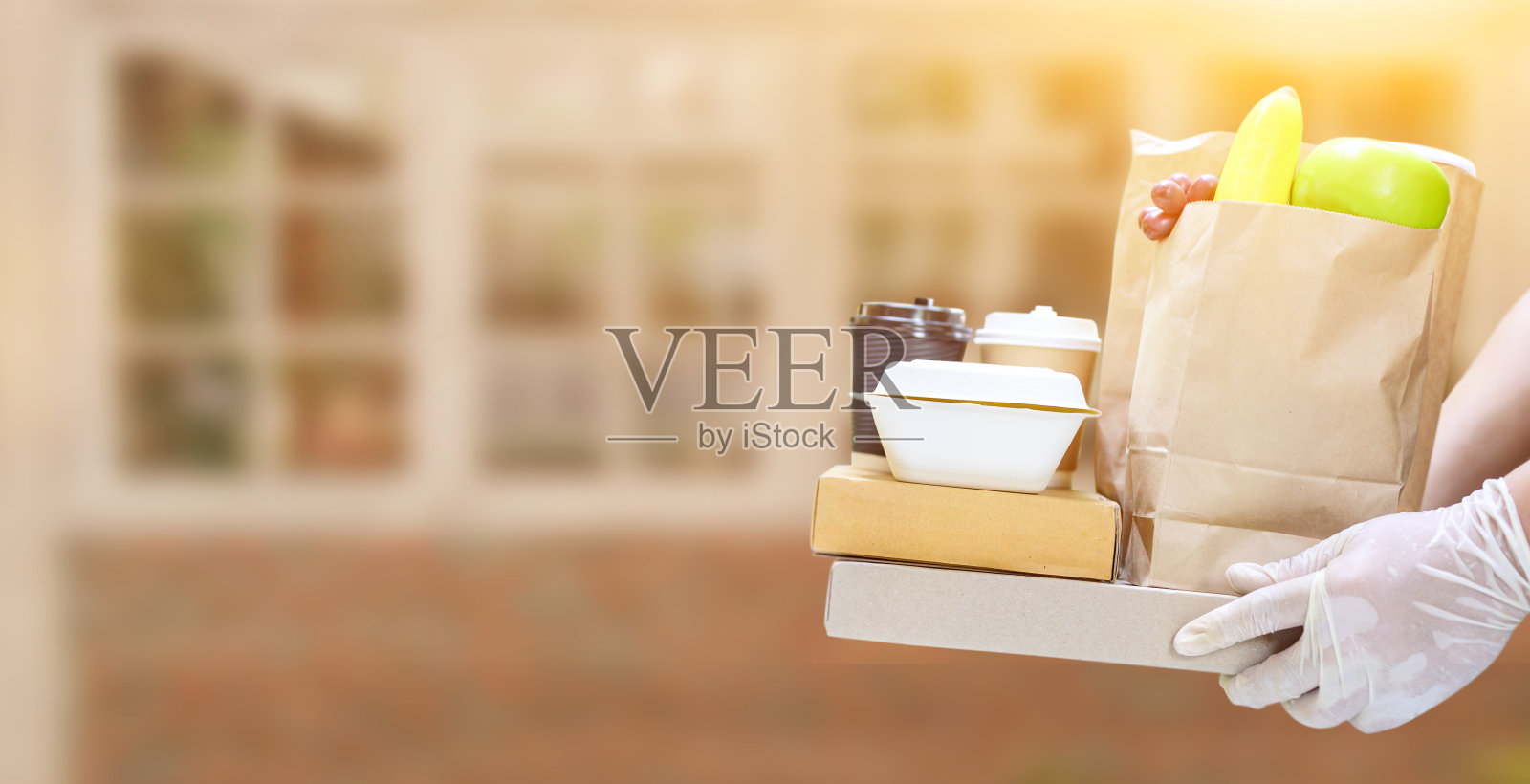 食物和送货上门。送餐员戴着橡胶手套。照片摄影图片