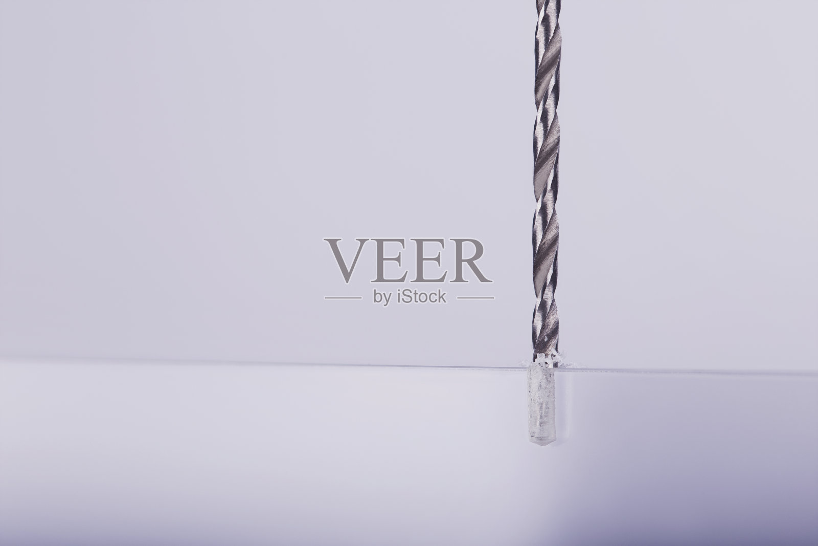 钻头在不透明的塑料、玻璃坯料上钻孔照片摄影图片