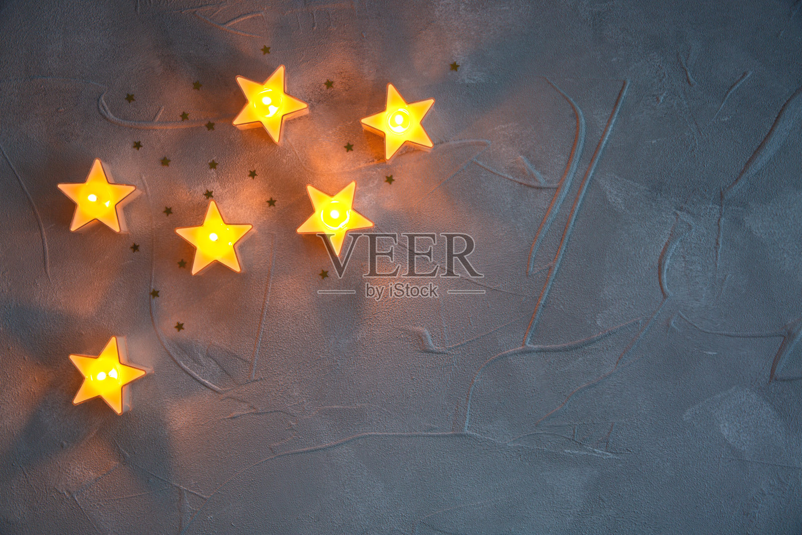 圣诞装饰星星蜡烛在灰色纹理的背景发光照片摄影图片