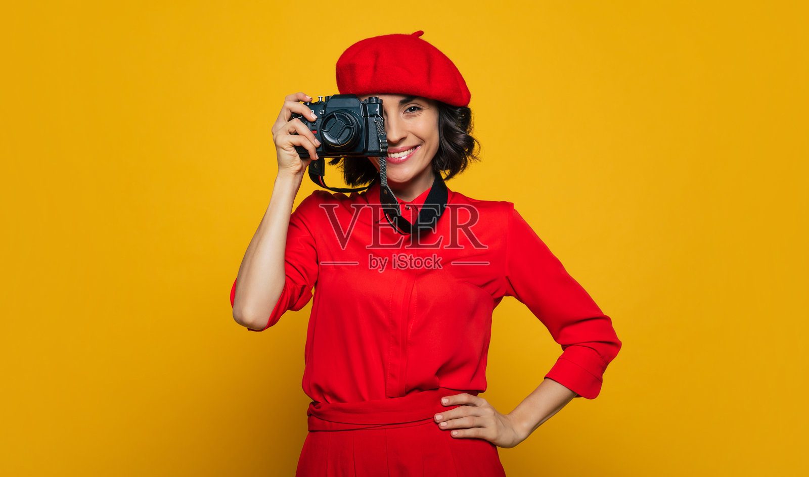 大家都笑得很开心!一个可爱的露齿微笑的女人在她的假期的半长照片，法国风格的穿着，带着一个相机在她的脖子上，准备拍照。照片摄影图片