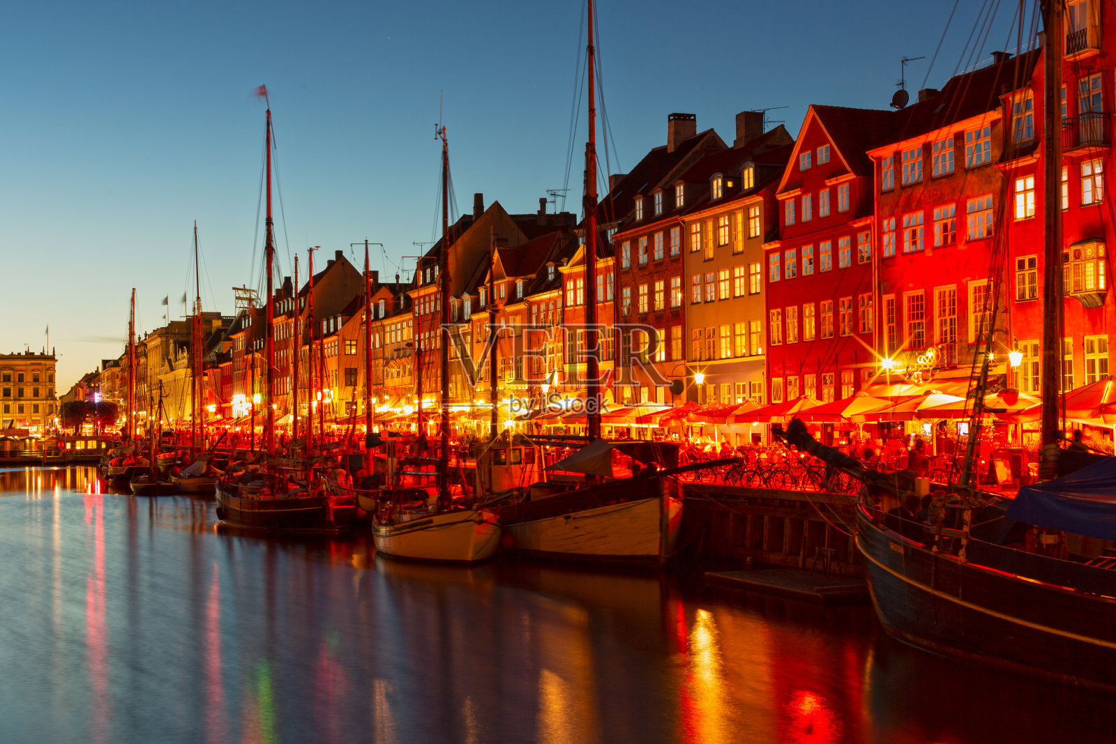丹麦哥本哈根夜晚的城市景观，著名的尼哈芬码头，五颜六色的建筑和船只照片摄影图片