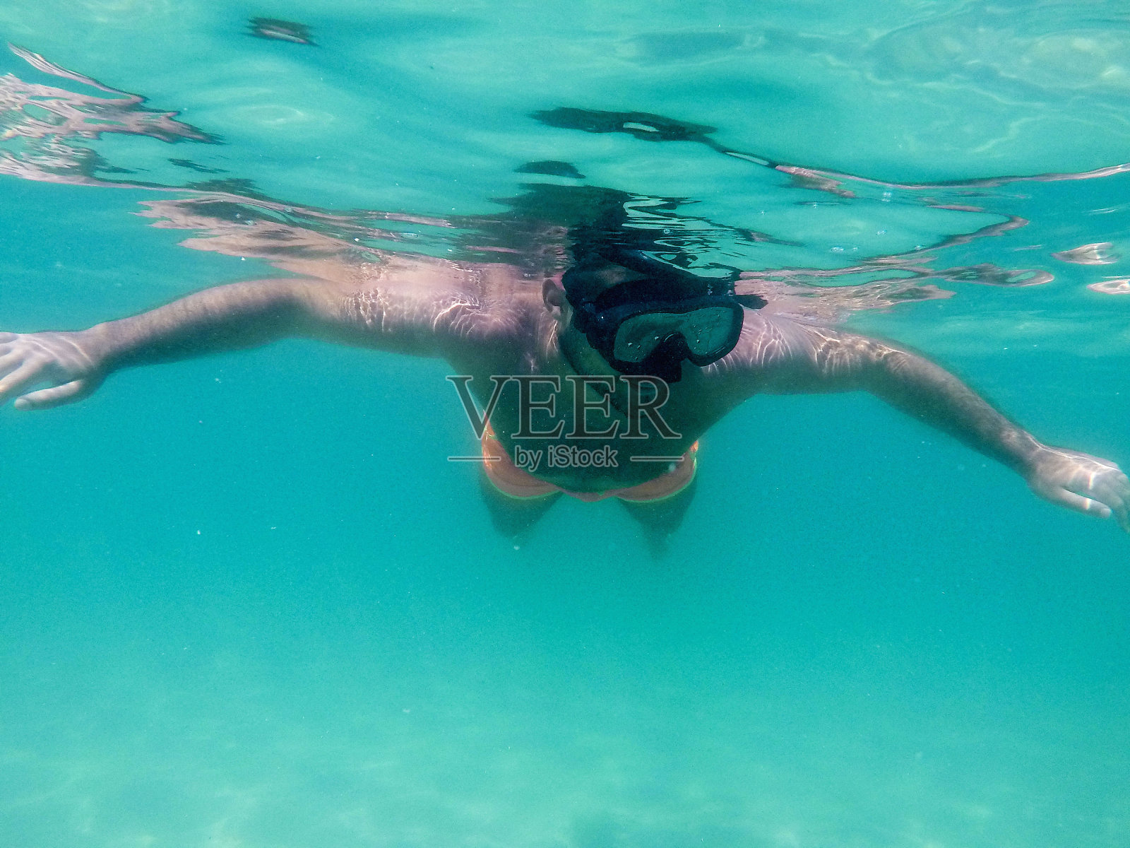 戴面罩的人在清澈的水中潜水照片摄影图片
