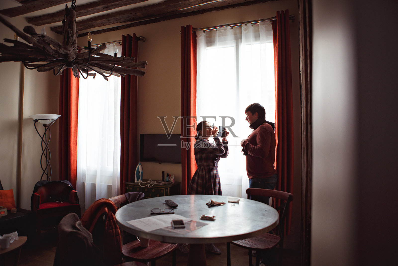 一对正在散步的夫妇。一个男人在等一个女人。窗边女孩的剪影。照片摄影图片