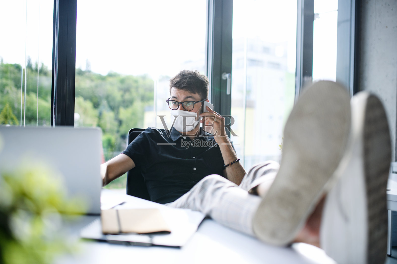 年轻人戴着口罩回到工作或学校，在办公室禁闭后，玩得很开心。照片摄影图片