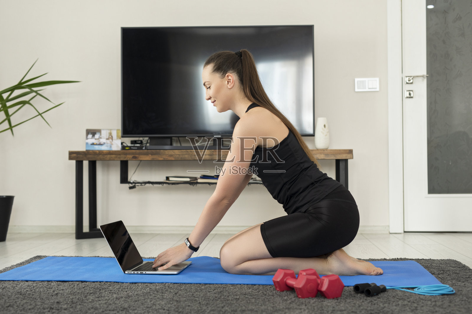 年轻女子穿着运动服使用笔记本电脑照片摄影图片