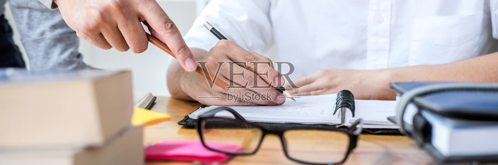 教育、教学、学习理念。高中学生或同学小组辅导在图书馆学习和阅读，帮助朋友做作业和课练习，准备考试入学照片摄影图片