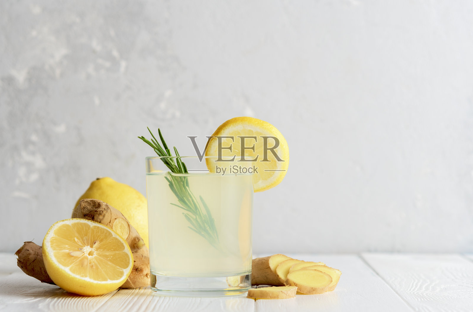 一杯姜水和柠檬在混凝土表面。照片摄影图片