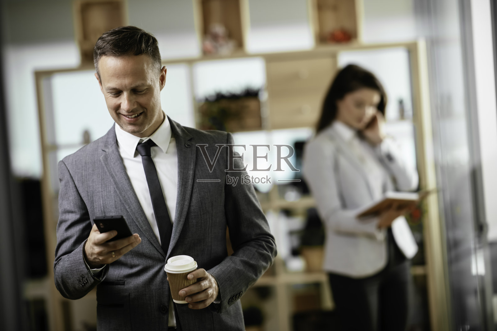 英俊的商人在办公室打电话。照片摄影图片