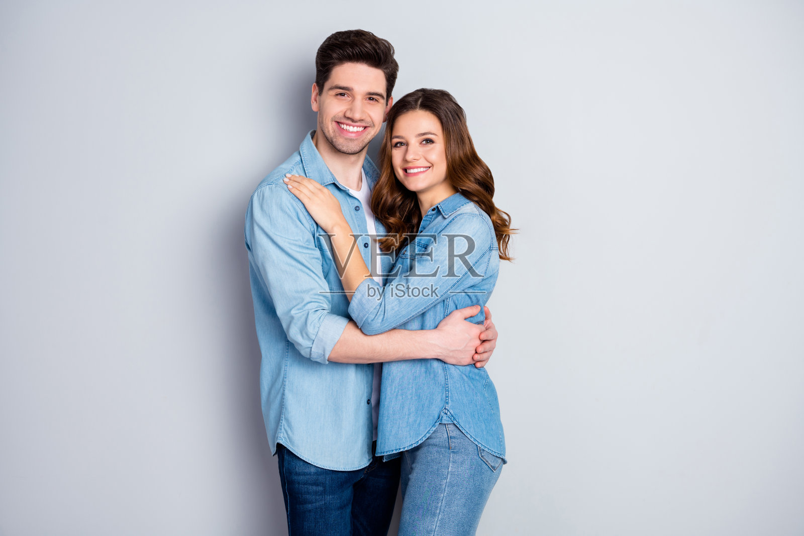 照片女士男生情侣在爱站在一起拥抱牵手浪漫的感情约会穿休闲牛仔衬衫外套孤立的灰色背景照片摄影图片
