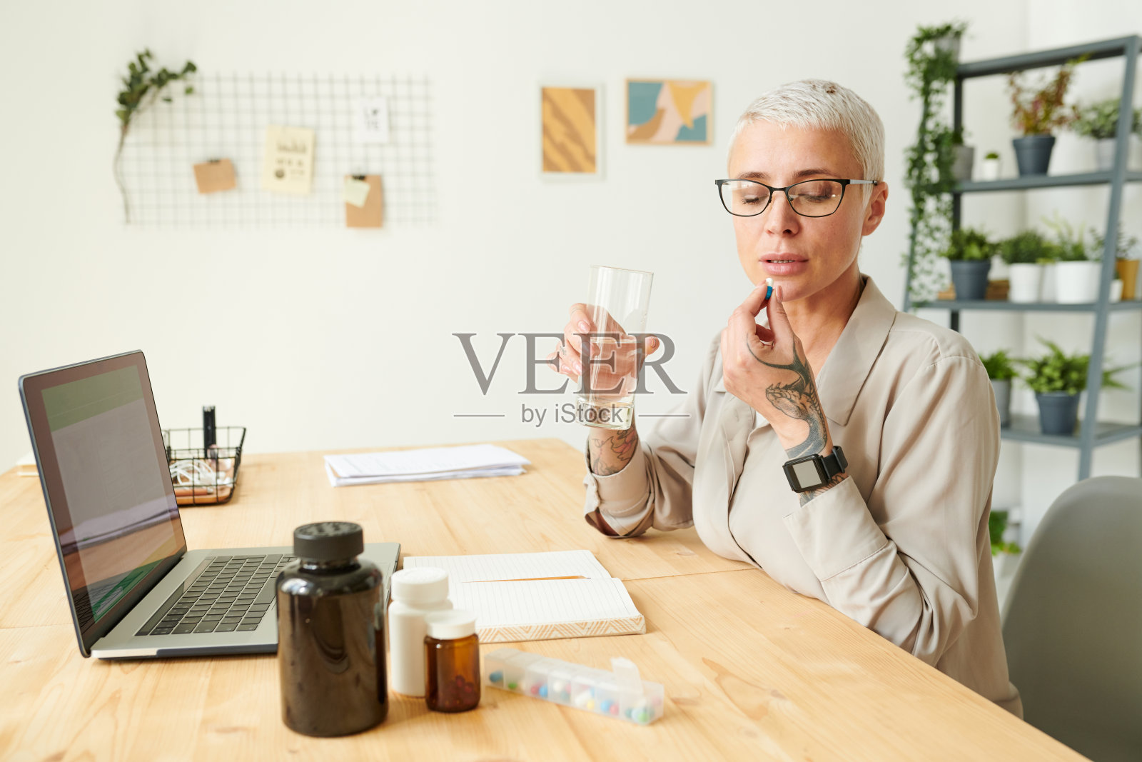 穿着衬衫的短发女商人服用药丸并配水饮用补充剂对提高生物黑客技能的影响照片摄影图片