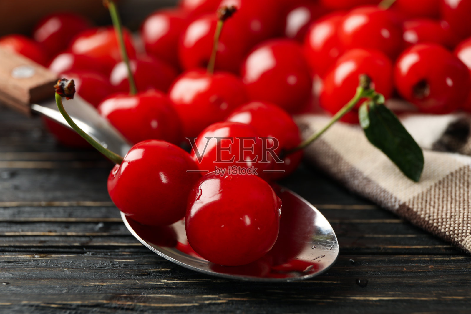 毛巾和勺子与樱桃木背景，特写照片摄影图片