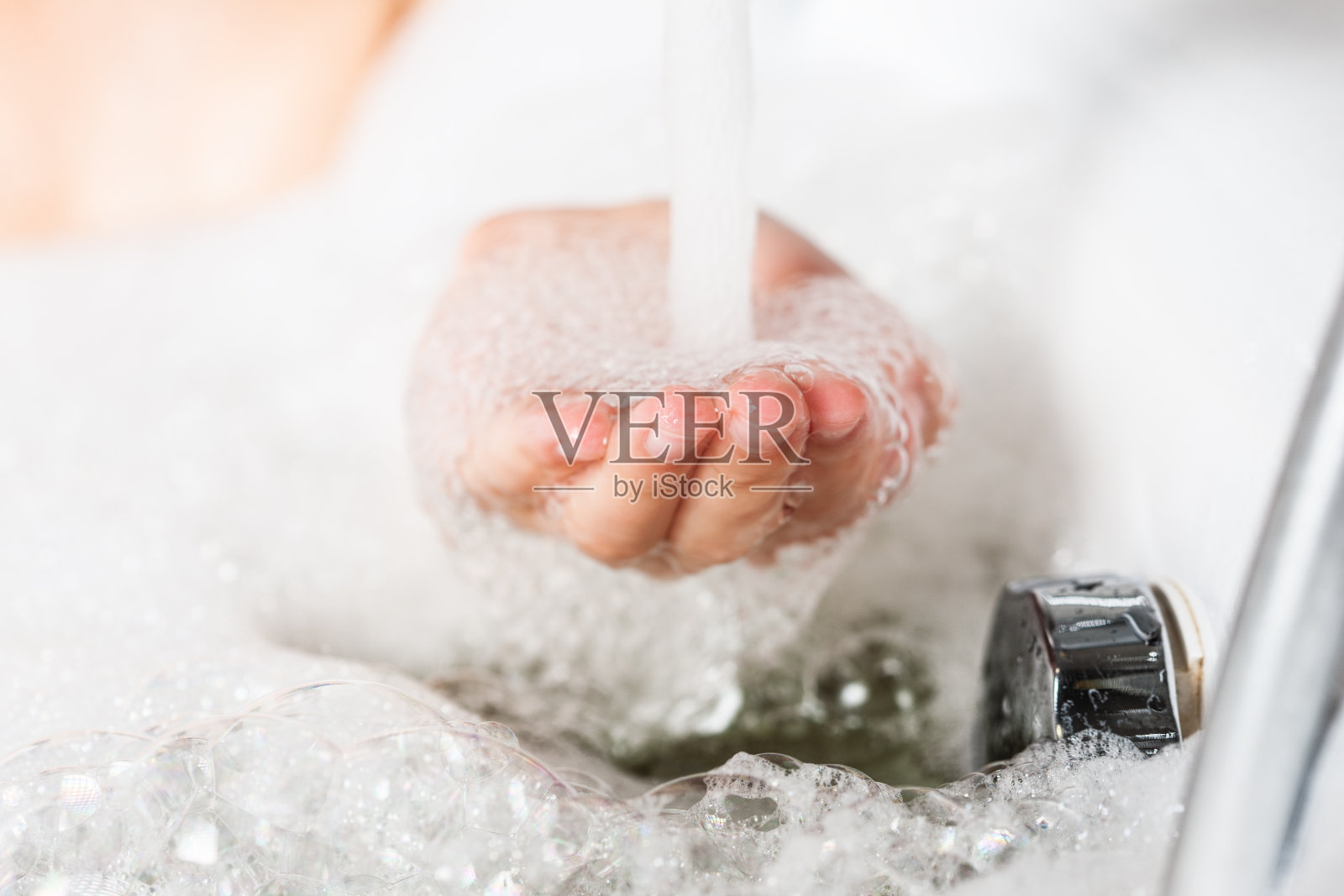 接近女性的手在肥皂泡沫下被替换照片摄影图片