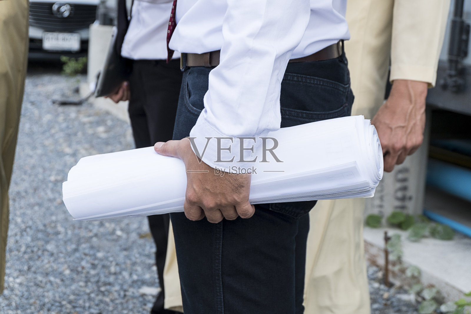 带着纸上计划的年轻工程师。照片摄影图片