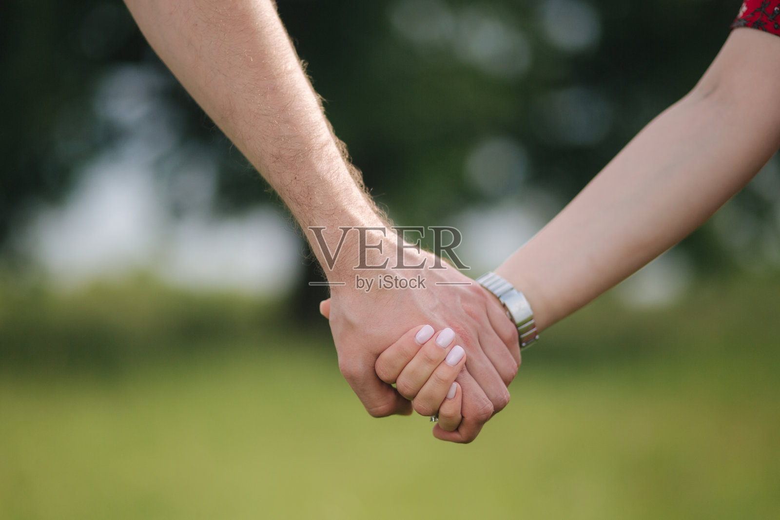 近距离的男人和女人在树前手牵着手照片摄影图片