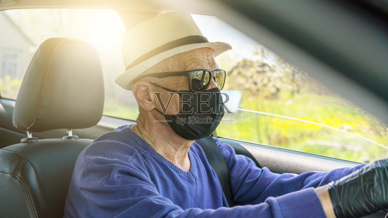 老人戴着太阳镜和面具开车的特写镜头照片摄影图片