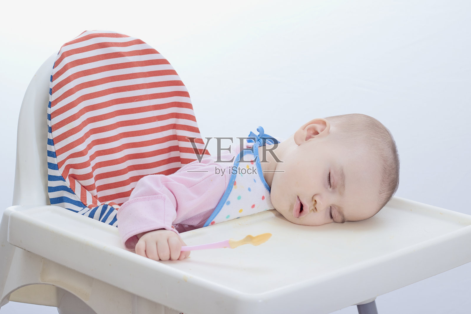 婴儿在单独的白色背景下进食时睡着了照片摄影图片