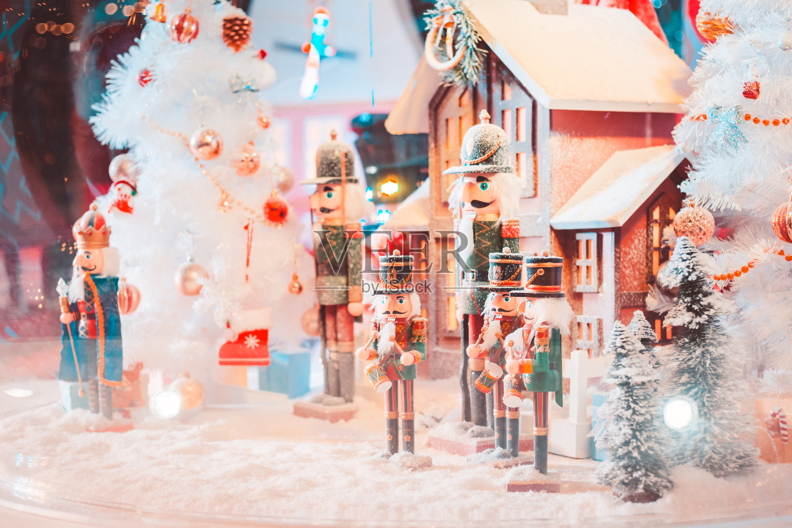 军队的圣诞娃娃和房子里有雪的大玻璃球和灯。照片摄影图片