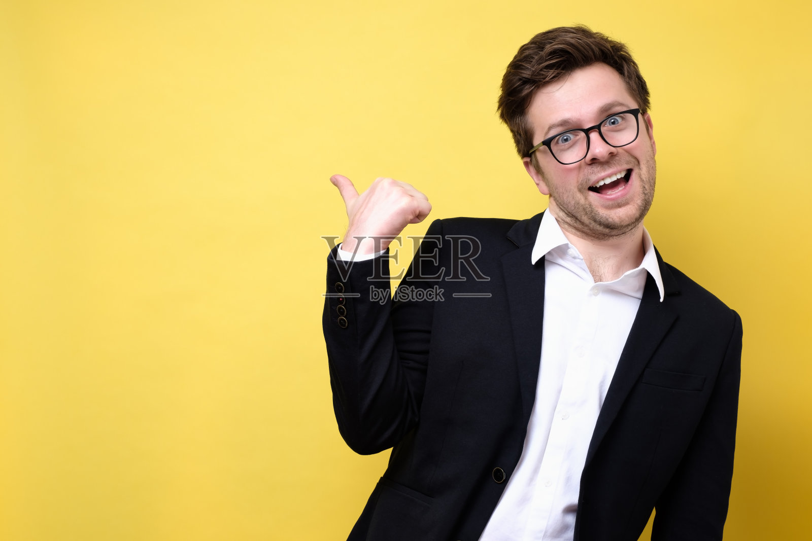 白人年轻人穿着西装微笑着指着一边照片摄影图片