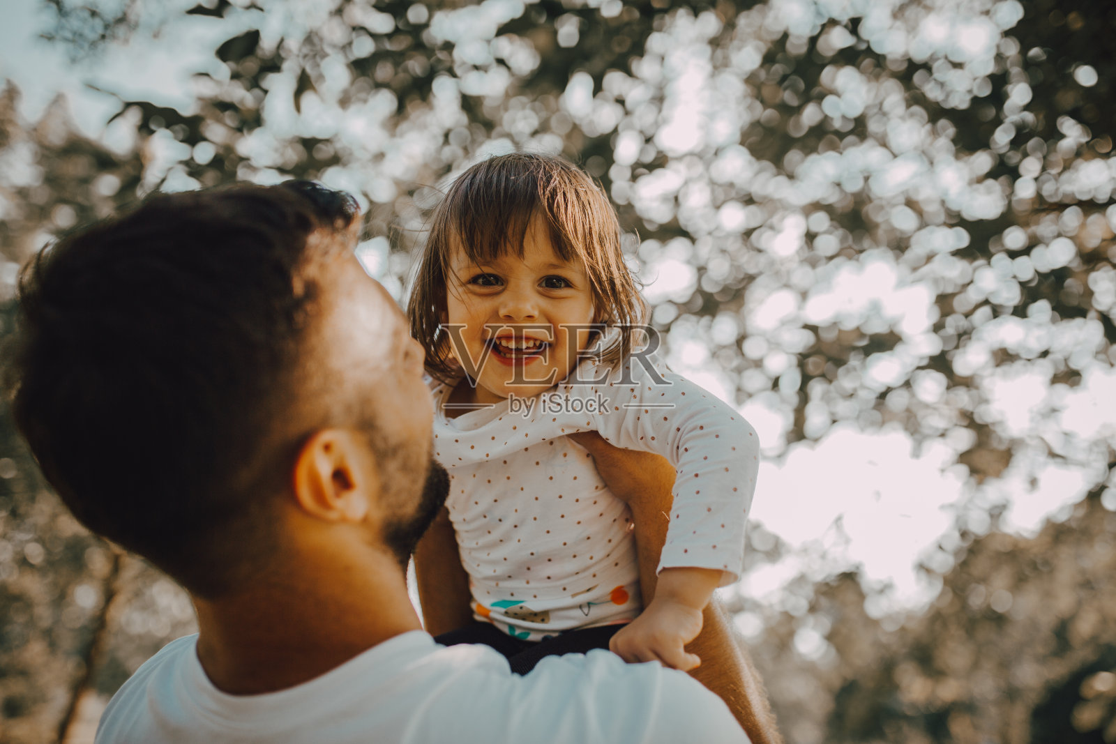 父亲抱着女儿在公园里照片摄影图片