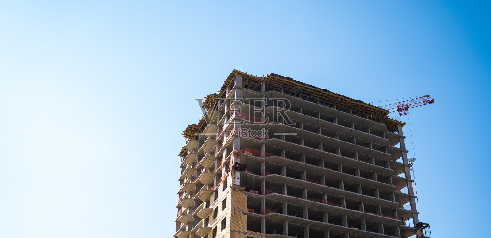 用起重机建造的现代建筑。在晴朗的天空下用高吊车建造建筑照片摄影图片