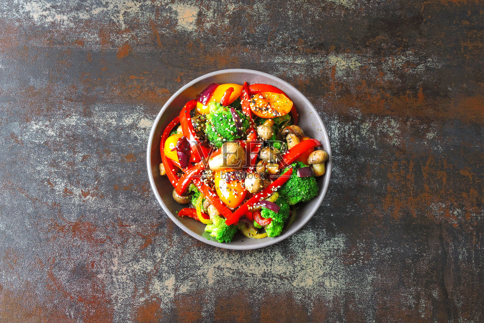 椰菜，蘑菇和红辣椒的热沙拉。照片摄影图片