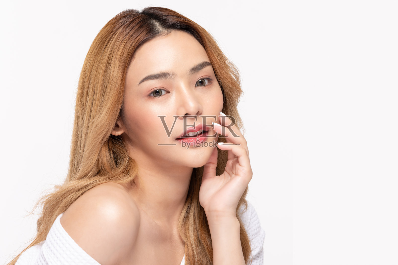 美丽的亚洲女人穿着浴袍微笑触摸脸颊清洁和新鲜的皮肤幸福和开朗与积极的情绪，隔离在白色的背景，美容化妆品和spa治疗理念照片摄影图片