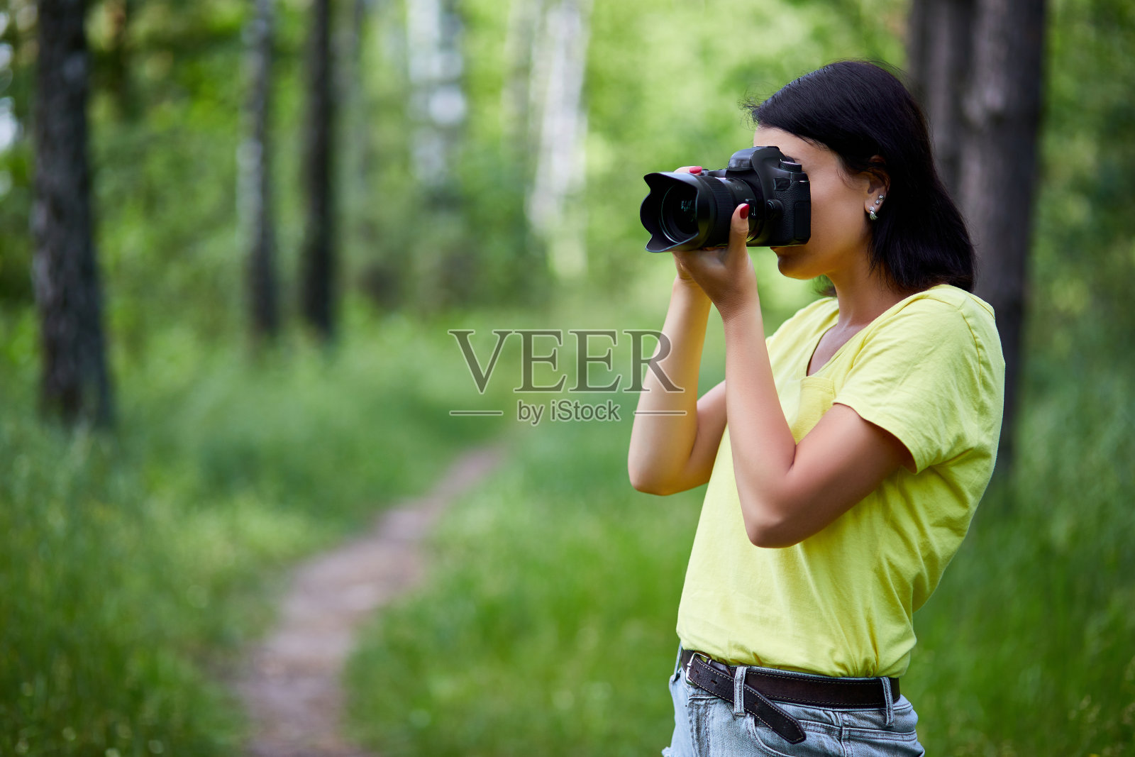 一个女摄影师用相机遮住她的脸的肖像照片摄影图片