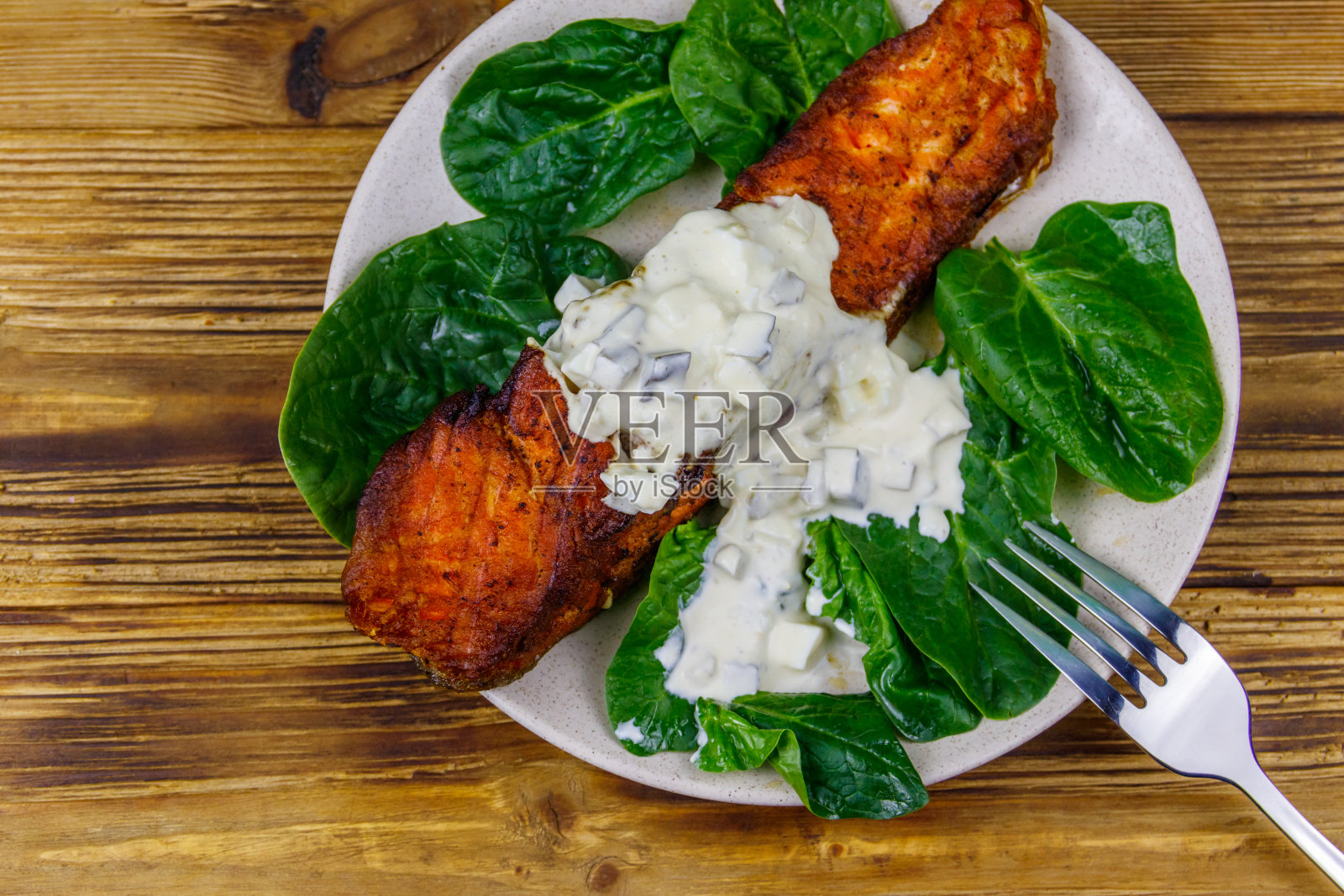 烤三文鱼片配菠菜和鞑靼酱放在木桌上。俯视图照片摄影图片