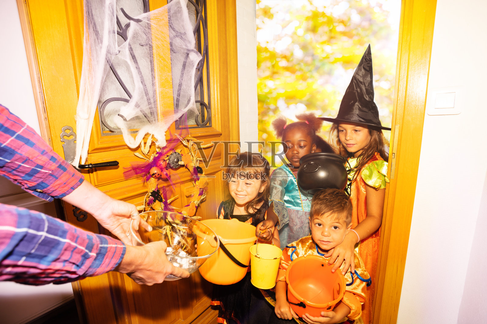 许多孩子在万圣节的桶里弄糖果照片摄影图片