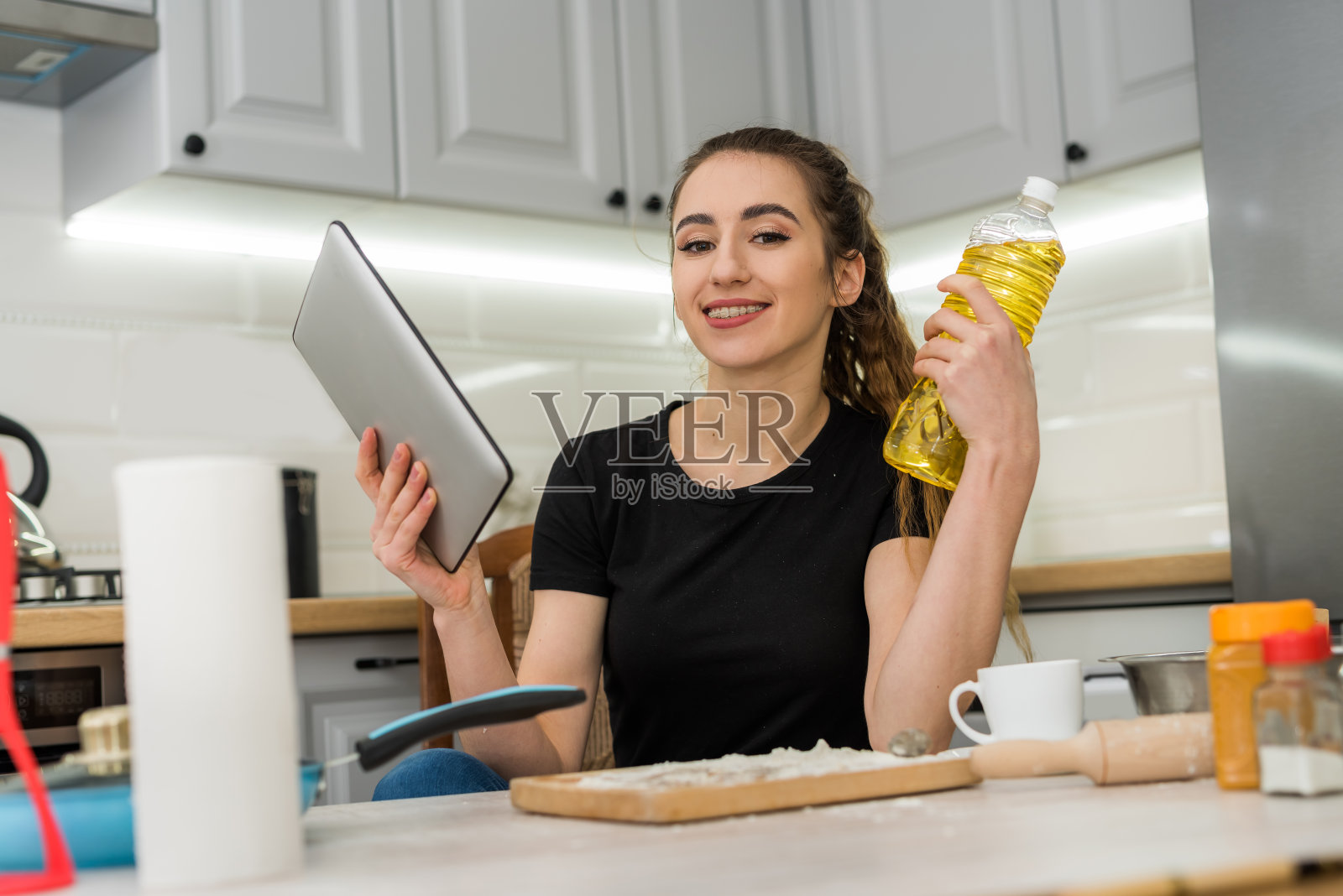 年轻漂亮的妻子准备在家里帮助数字平板电脑饼干照片摄影图片