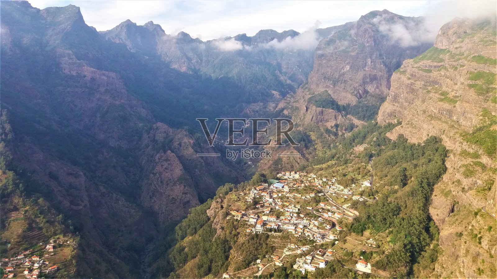 马德拉岛的山峦和山谷底部有一个小村庄，景色令人惊叹照片摄影图片