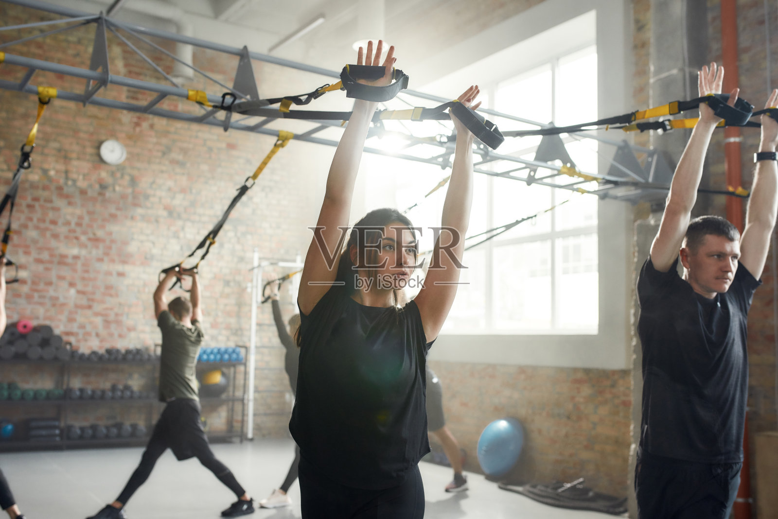 完整的身体。运动的年轻女子在工业健身房做健身训练练习。俯卧撑，团体锻炼的概念照片摄影图片