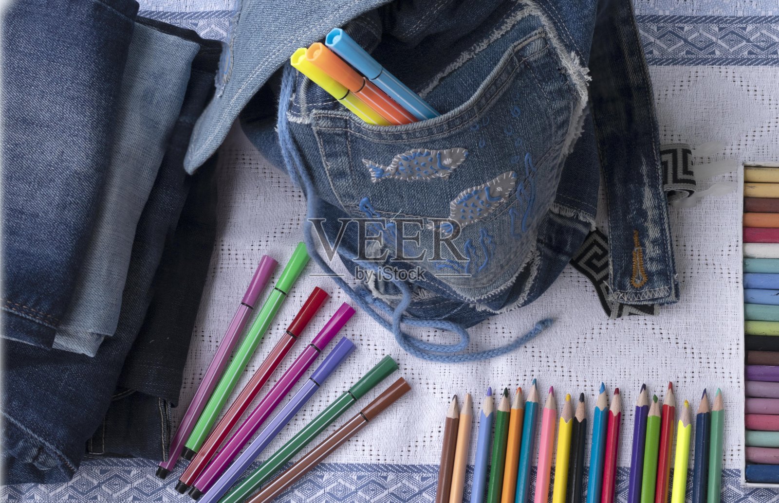 一套学校和办公用品在蓝色背景:钢笔，回别针，纸条，彩色铅笔，蜡笔，毡尖笔和闹钟。理念:回到学校。Flatlay顶视图。照片摄影图片