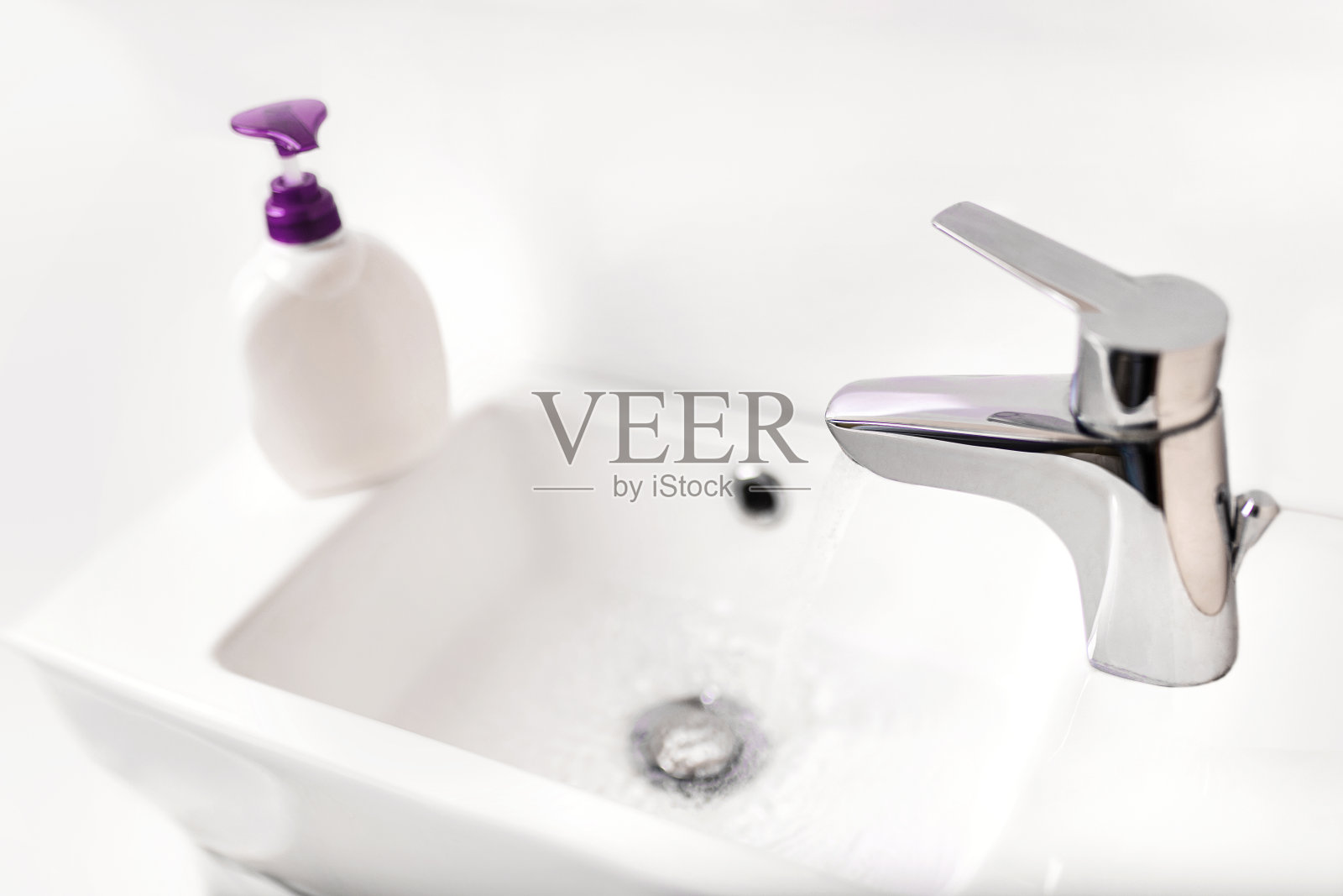 水龙头，水流，消毒剂。水龙头附近的消毒器和水龙头，用肥皂洗手，防止冠状病毒感染。照片摄影图片