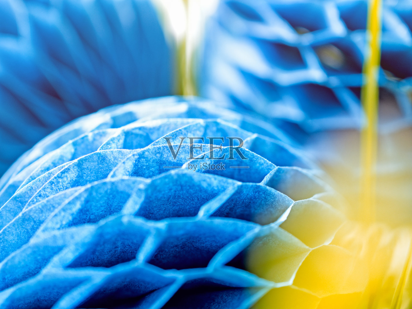 草中有一个用来装饰的蜂窝纸球。抽象的背景。宏观的形象。照片摄影图片