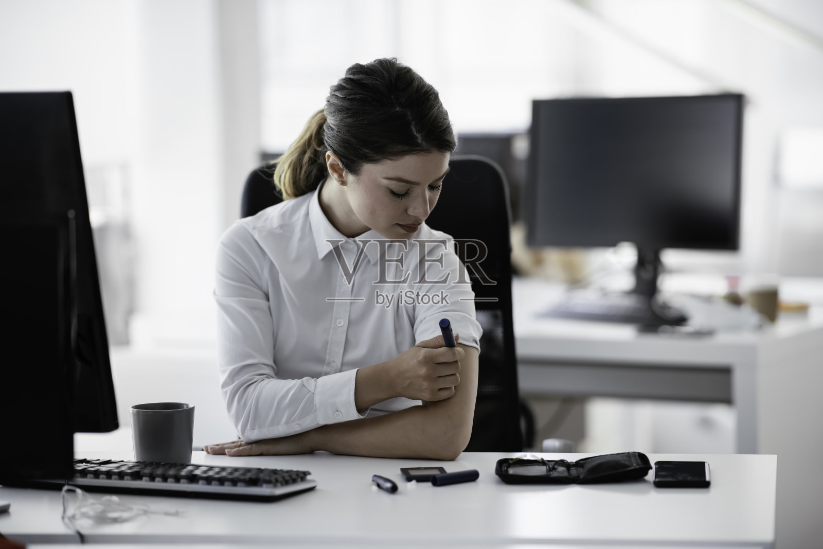 这位女商人正在给自己注射胰岛素。照片摄影图片
