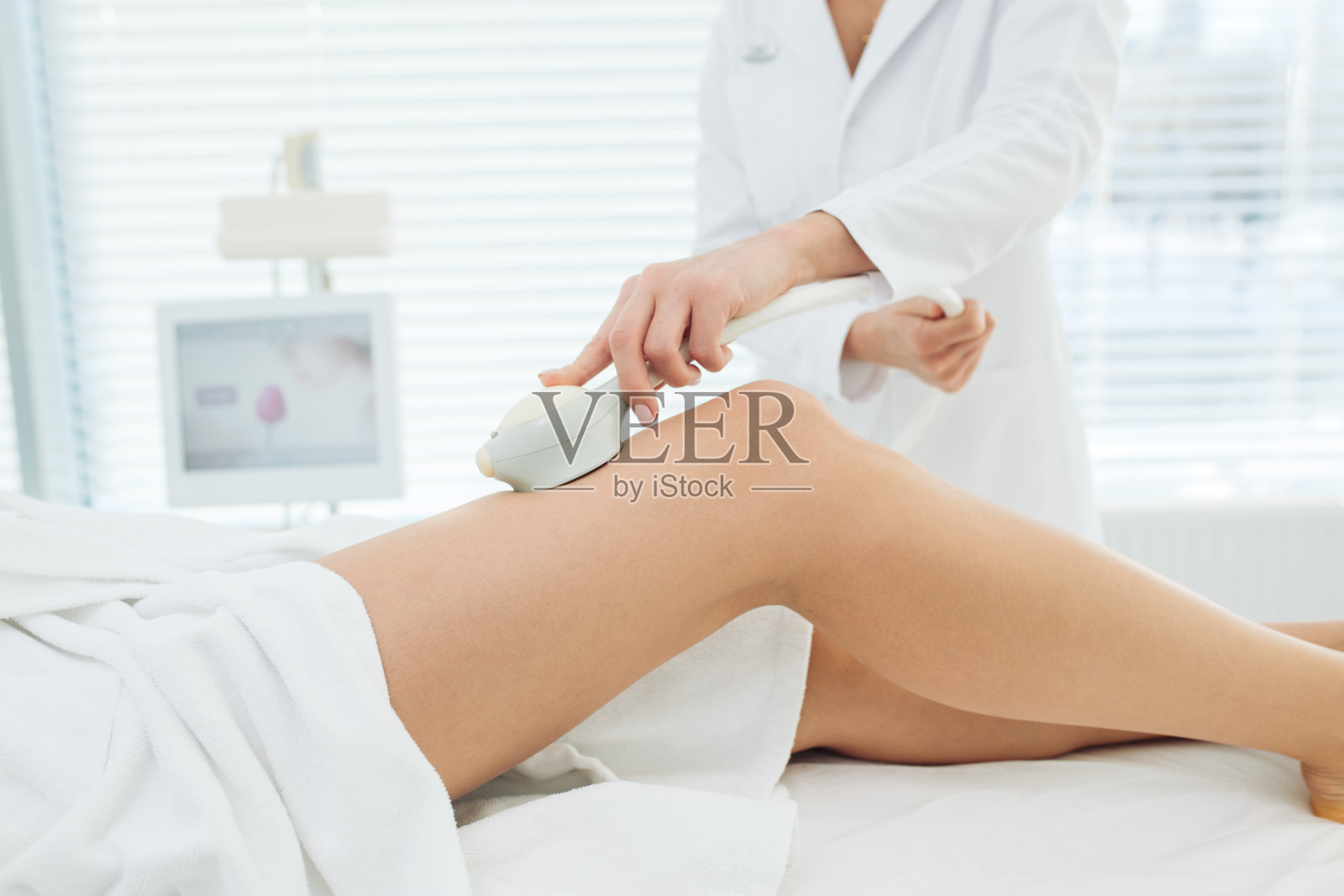 美容诊所的女性客户，正在接受腿部石油气按摩，以提升身体照片摄影图片