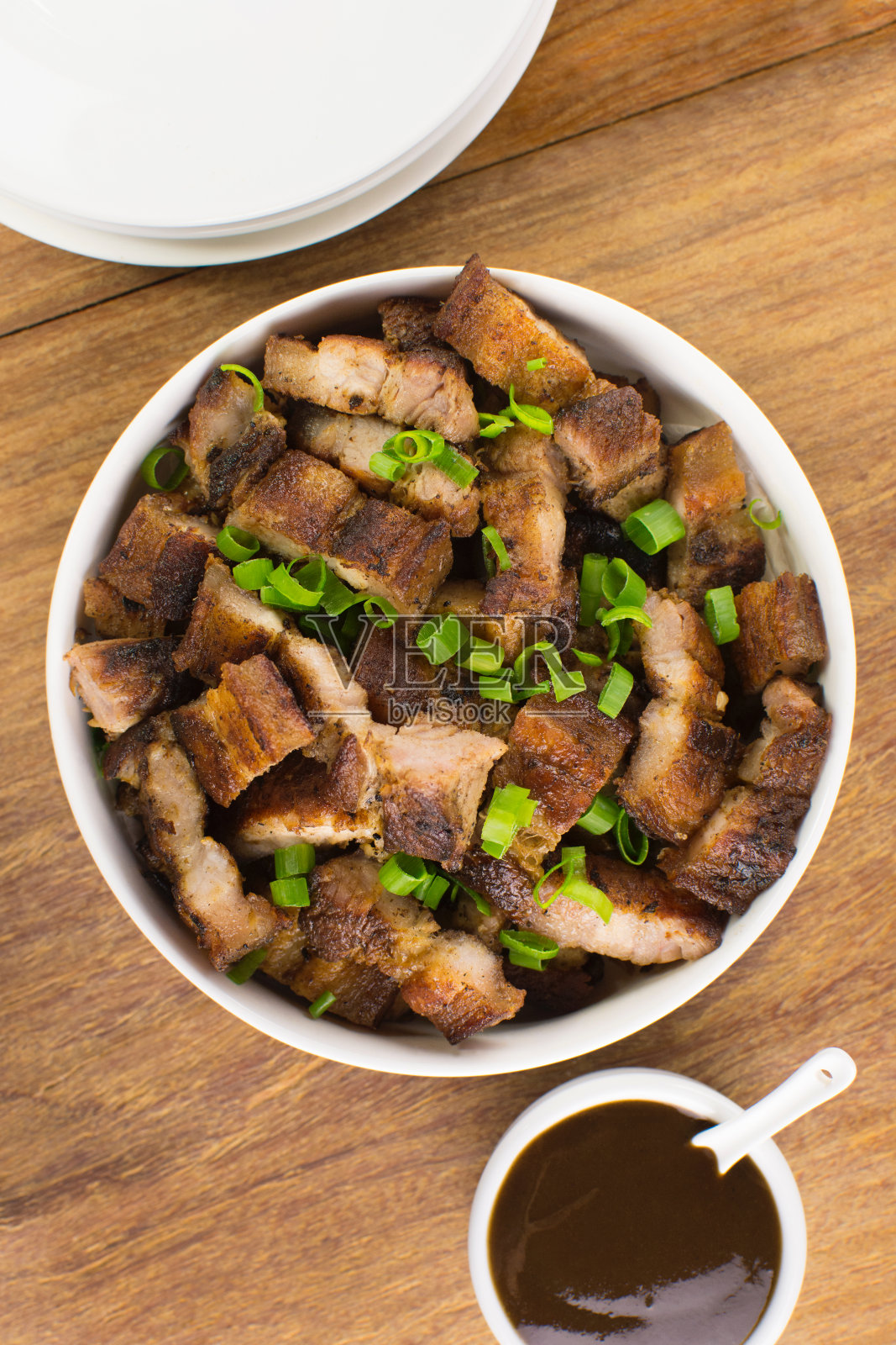 烤五花肉在一个白色的碗与烧烤酱和啤酒在木头酒吧桌子的背景从上面看照片摄影图片