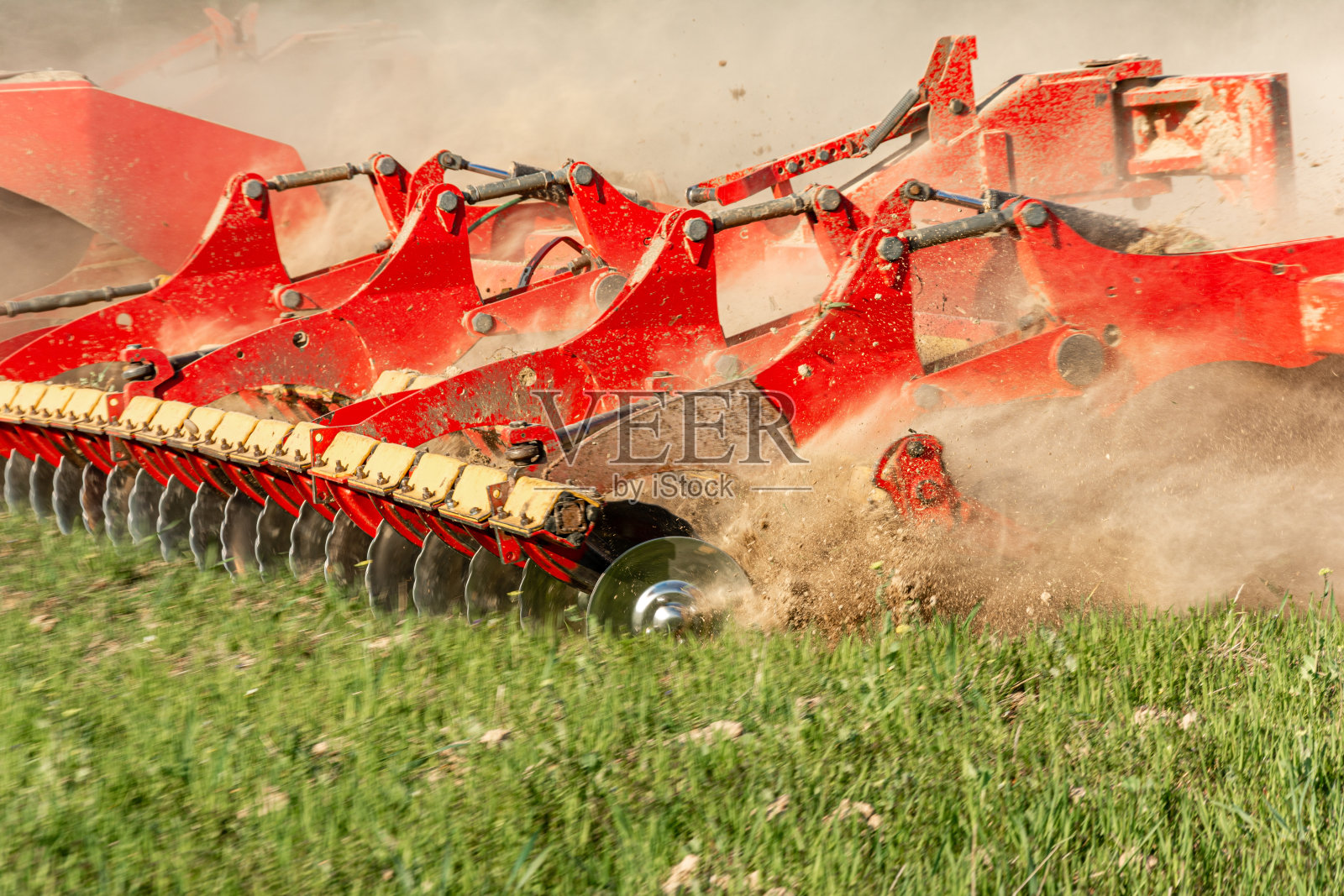 农业设备把耕地弄碎。履带式拖拉机拉着耙子拉近土壤。照片摄影图片