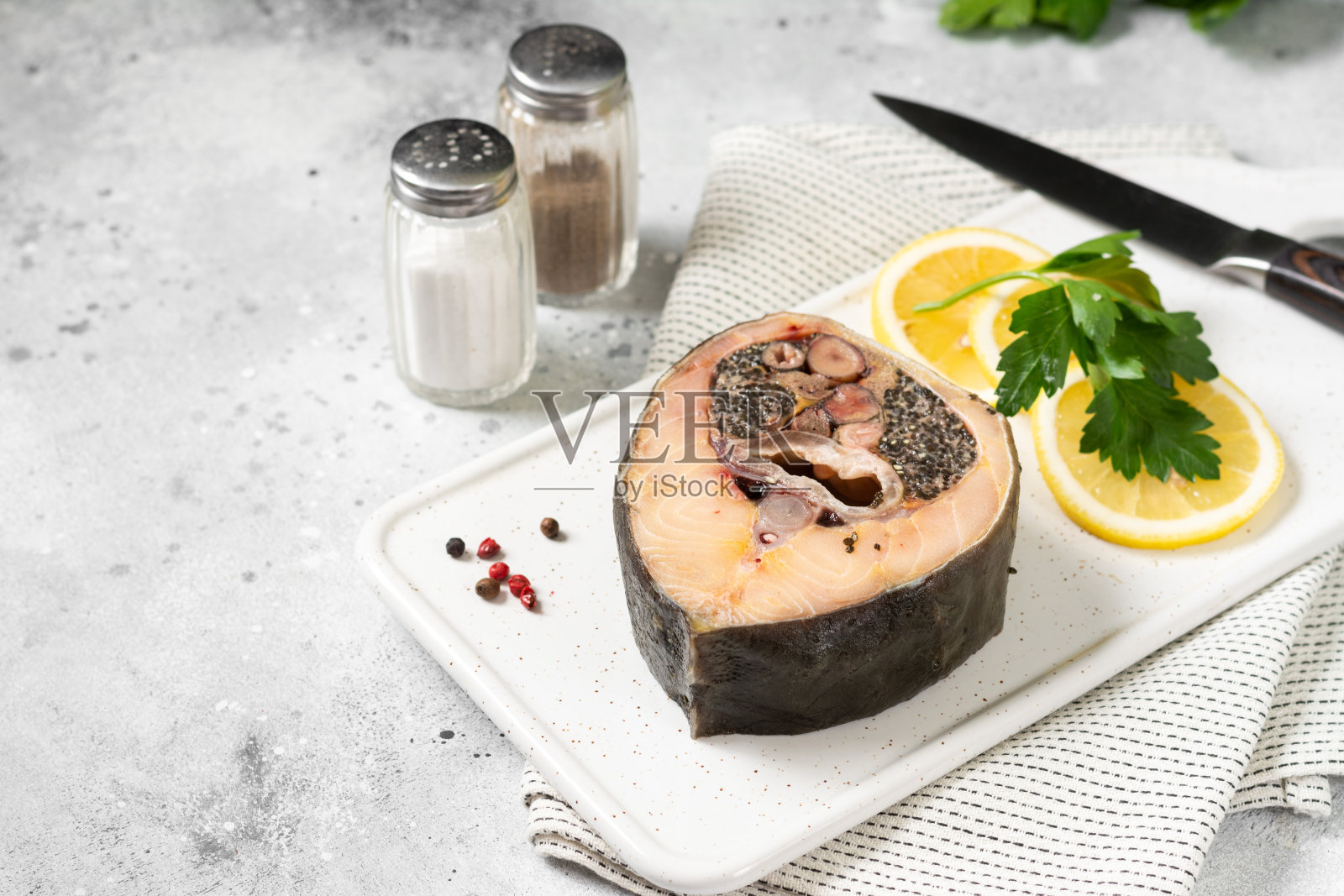 浅灰色的餐桌上，白色陶瓷盘子上放着野生鲟鱼排。健康的海鲜。带有文本空间照片摄影图片