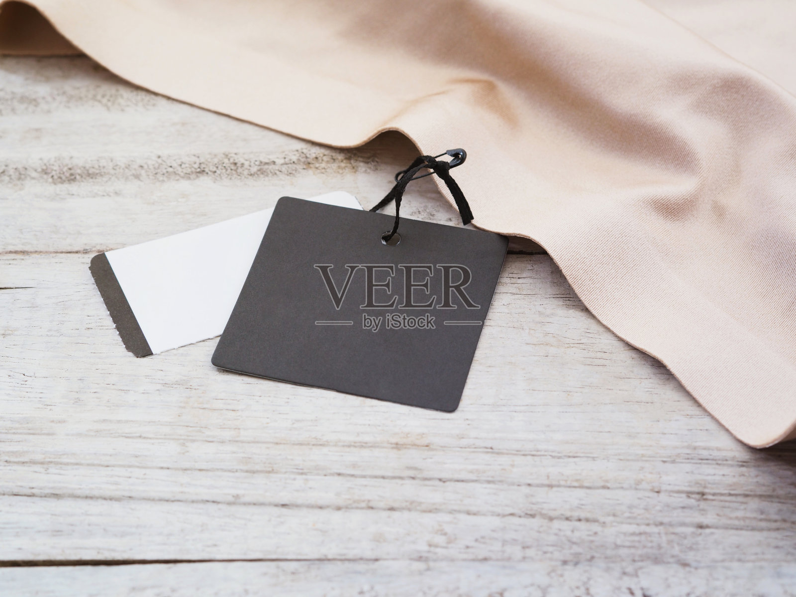 黑色的纸标签挂在丝绸上照片摄影图片