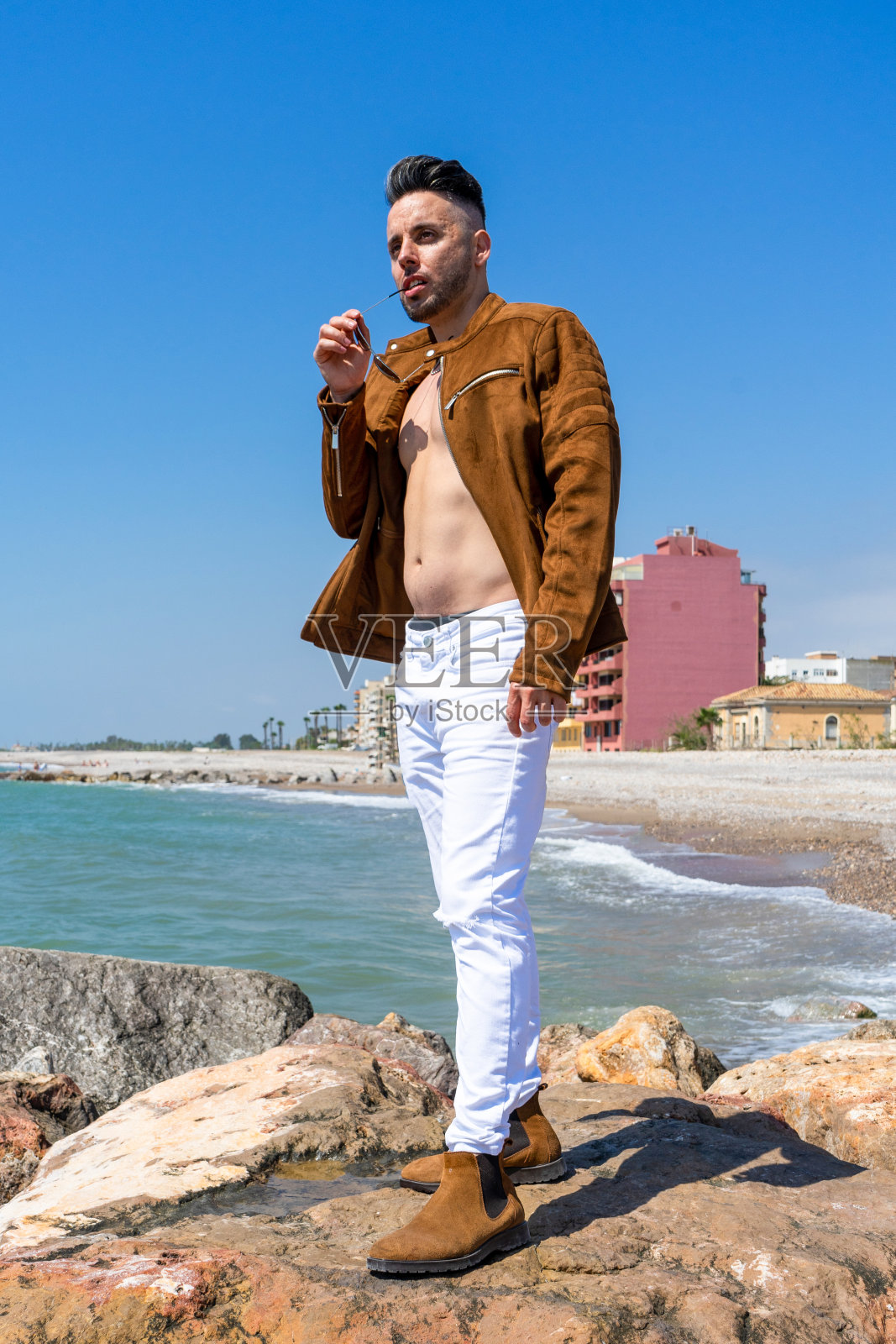 年轻男子穿着白色裤子和现代造型在地中海海滩在布里亚纳照片摄影图片