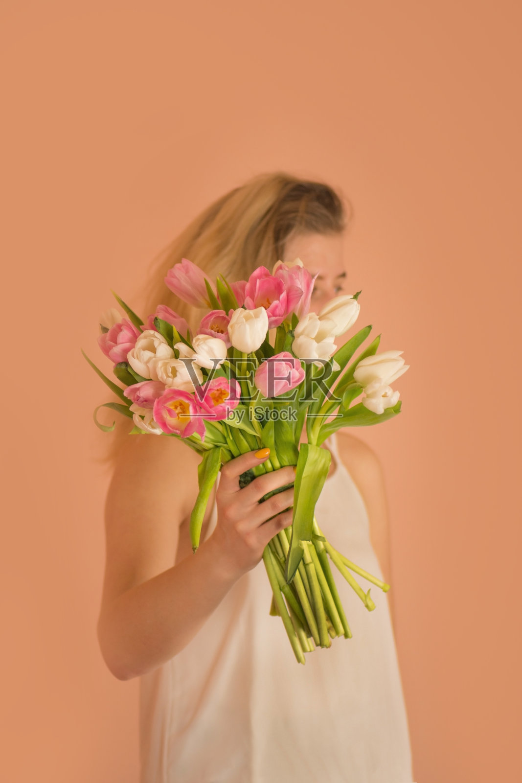 迷人的快乐女孩与一束花的米色背景照片摄影图片