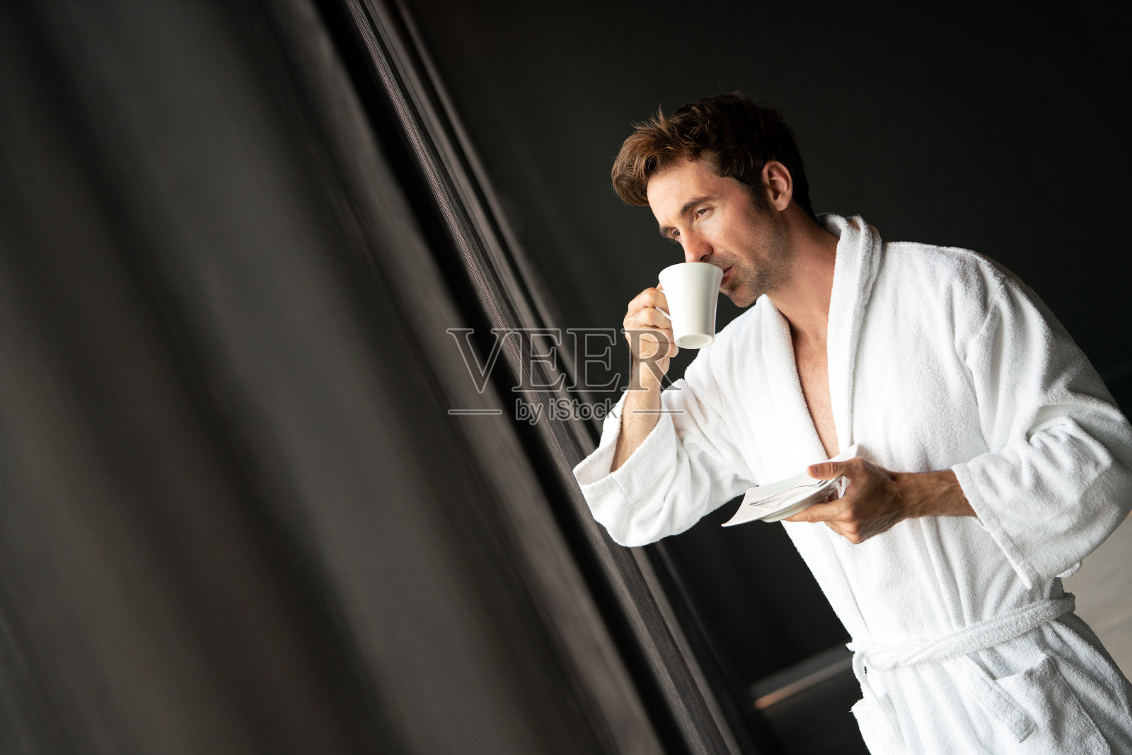 男在浴袍放松的同时喝茶照片摄影图片