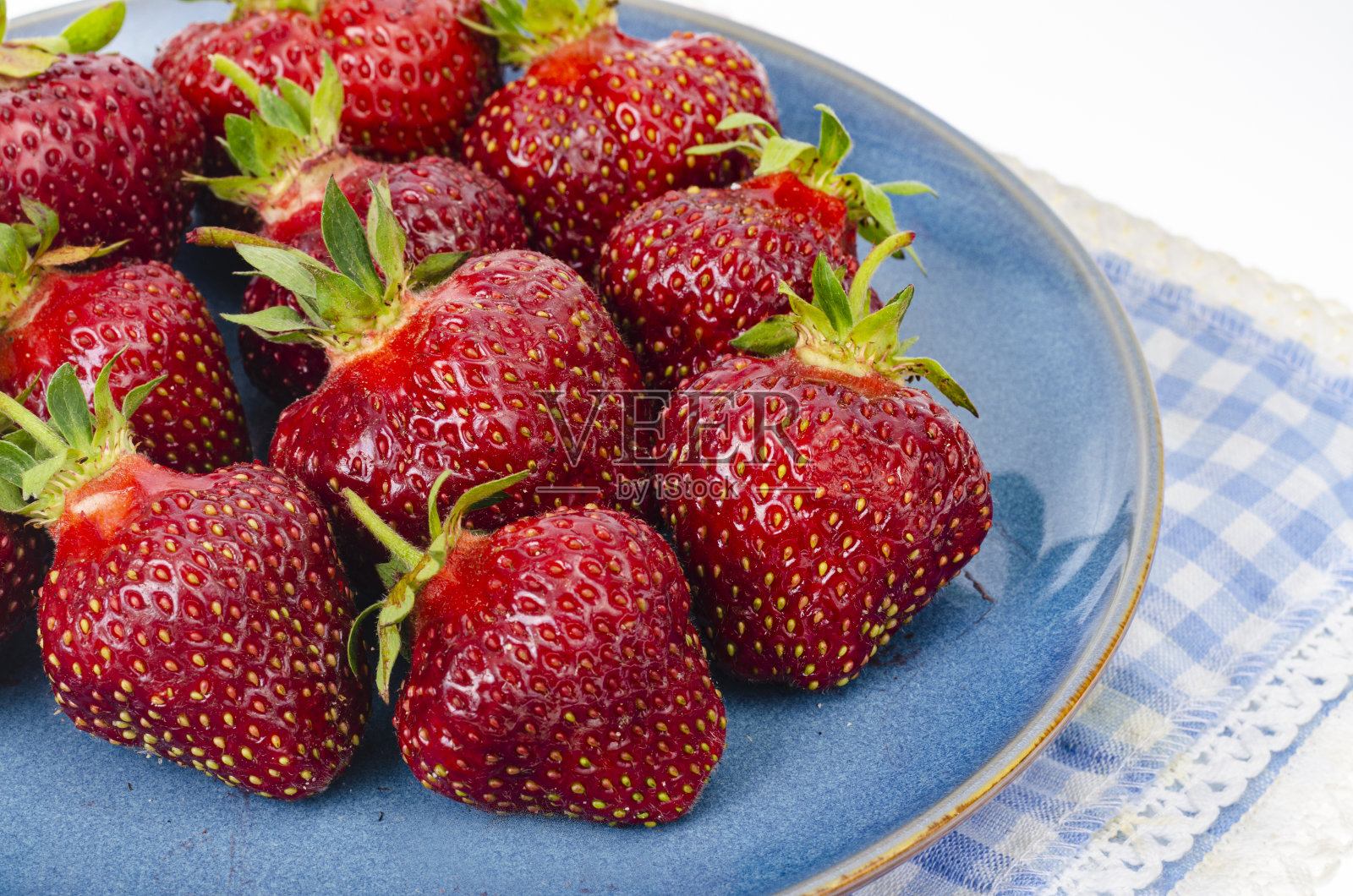 蓝色盘子里放着成熟的红草莓。照片照片摄影图片