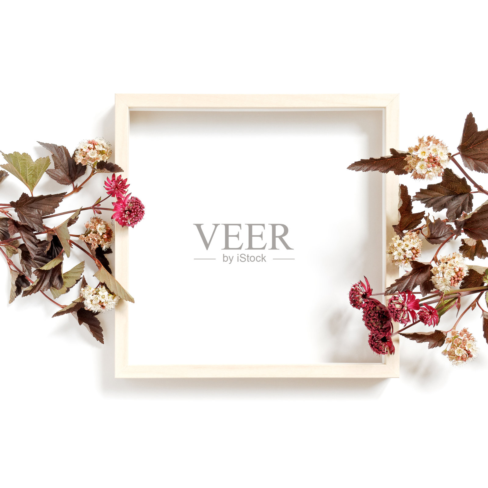 花组成。一个空的木制画框和盛开的花园或田野植物在白色的背景。夏秋概念。平的。副本的空间。照片摄影图片