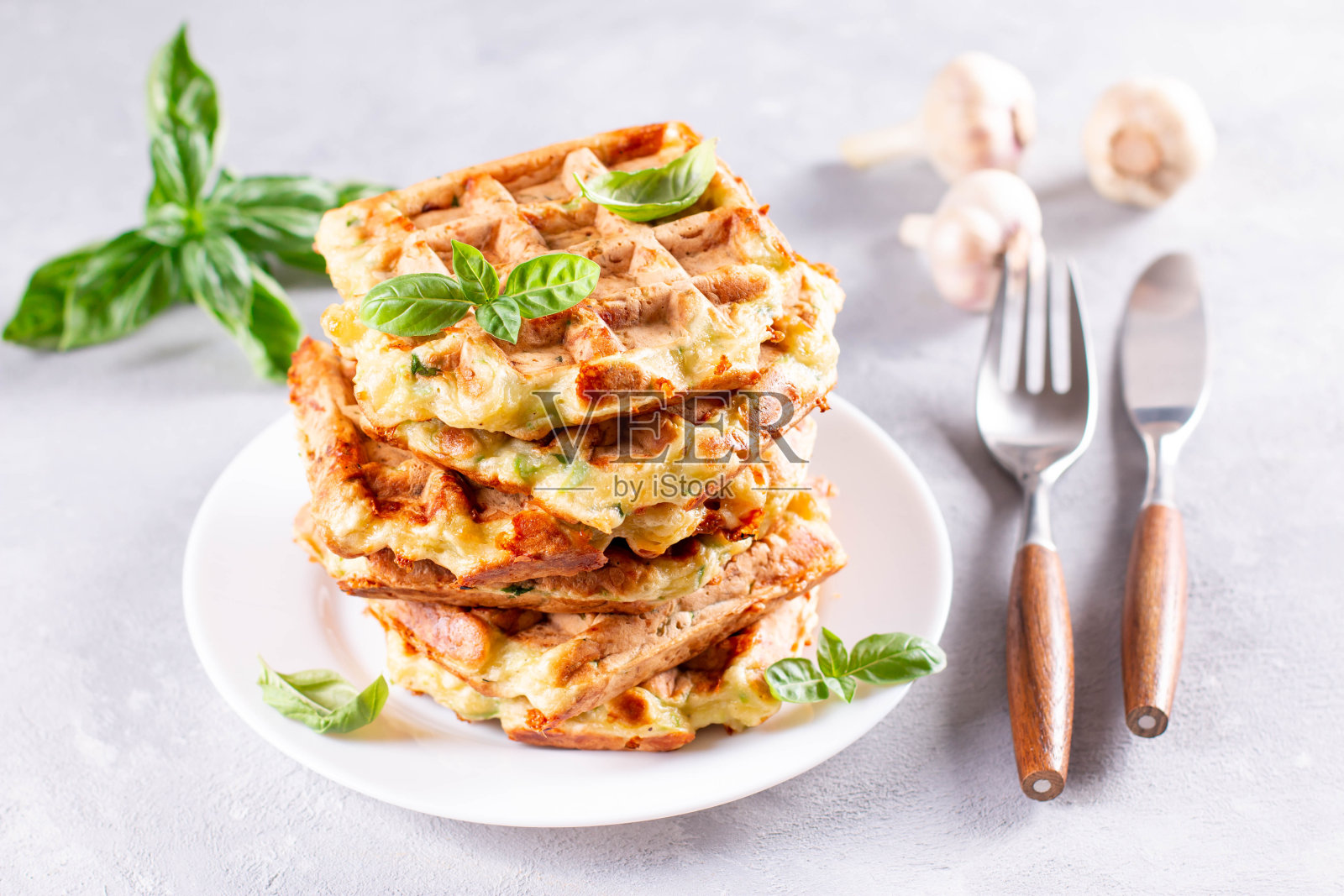 西葫芦华夫饼，在华夫饼机上烹饪的西葫芦油炸饼，素素西葫芦华夫饼配罗勒和大蒜，背景较轻照片摄影图片