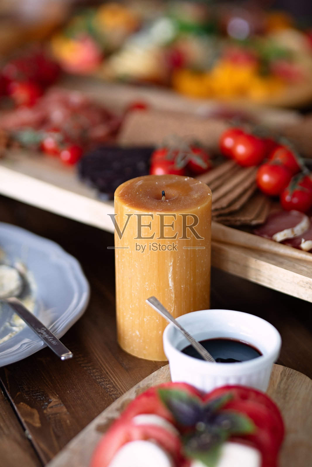 桌上摆着棕色的蜡烛和食物，彩色的菜肴作为背景，选择性的焦点，节日晚餐，照片摄影图片