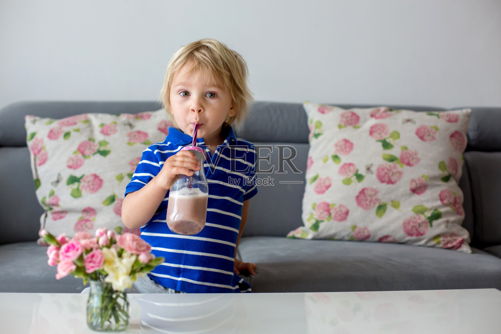 快乐的小男生喝着健康的冰沙照片摄影图片