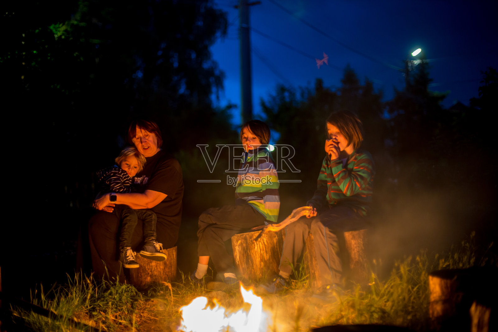 快乐的孩子们在篝火上烤香肠照片摄影图片